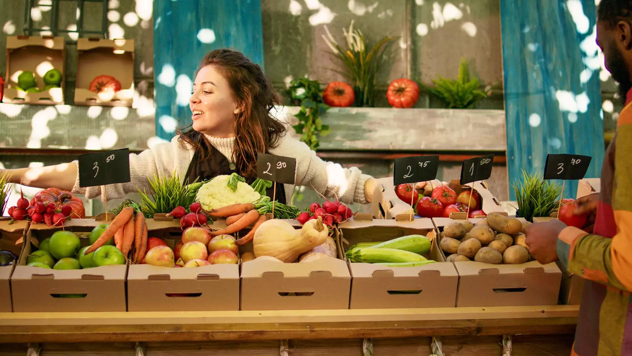 Un étalage coloré de fruits et légumes frais à vendre sur un marché de producteurs.