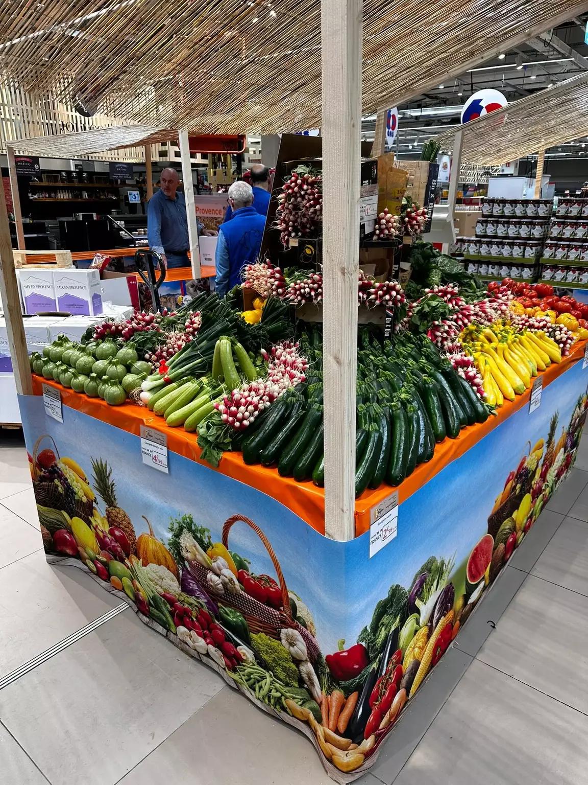 Stand de légumes rempli d'assortiments de produits frais dans un supermarché.